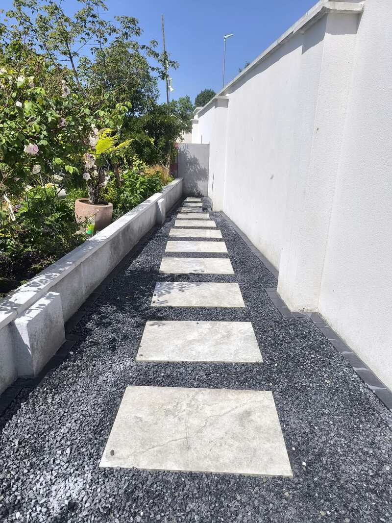 Stepping stones set in dark gravel along a side passage