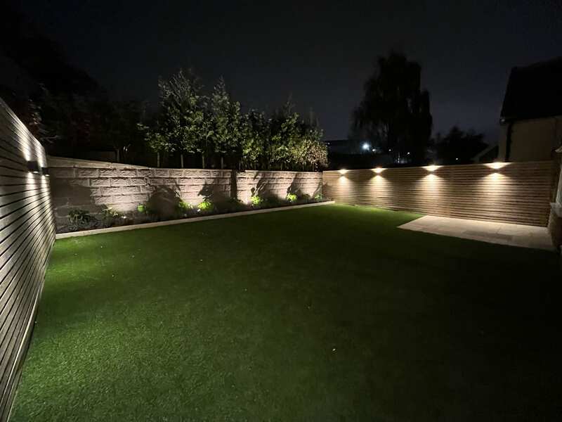 Finished patio with artificial lawn, raised beds and timber cladding